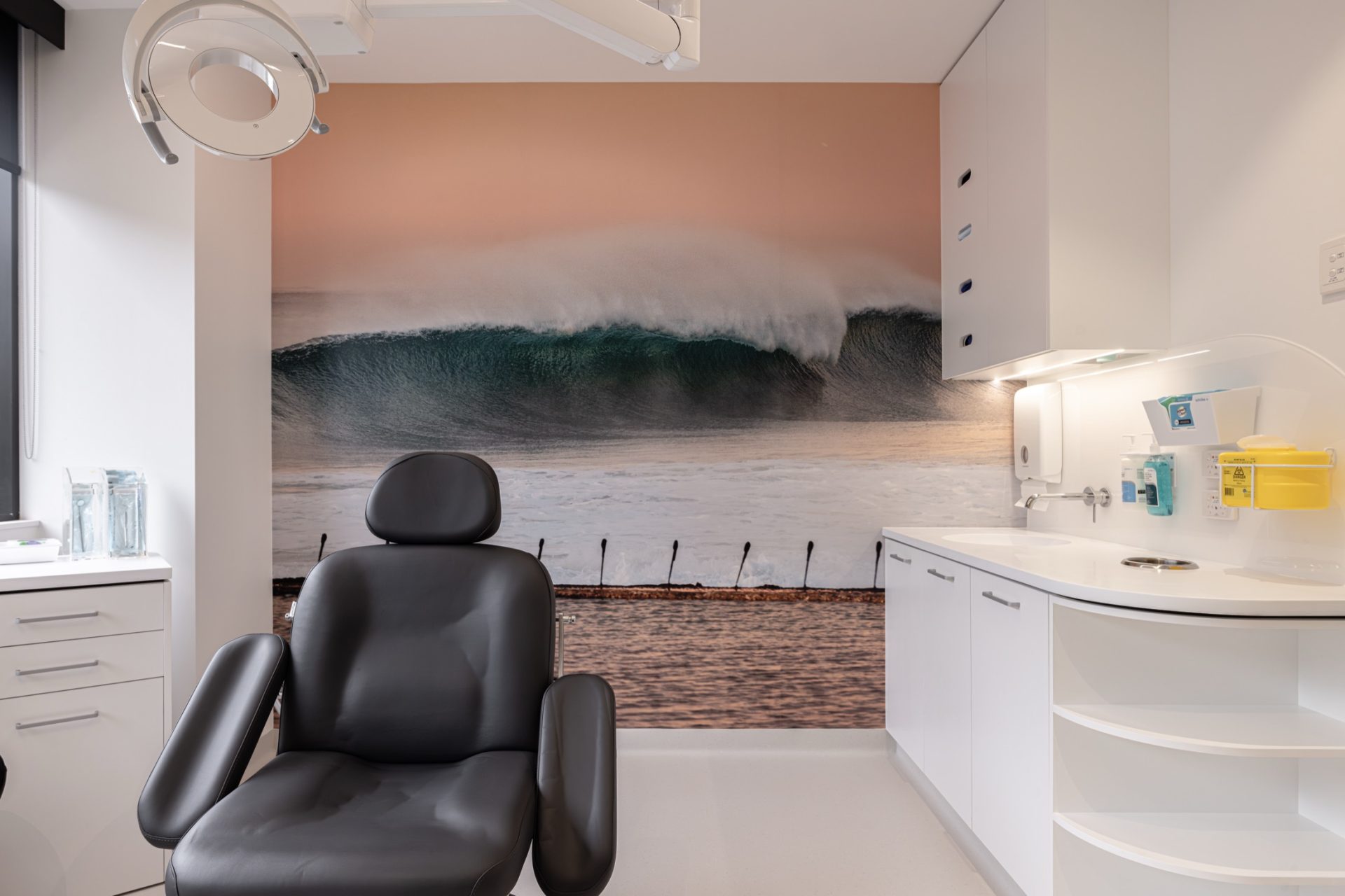 Treatment room at Hunter OMS with a full wall ocean wave mural